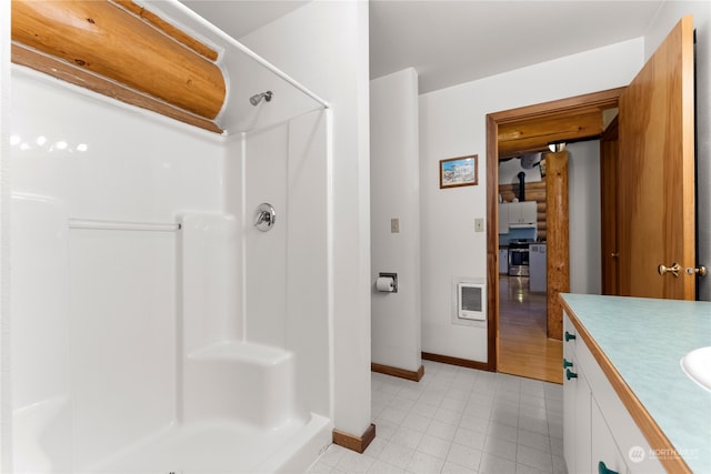 bathroom featuring tile flooring, walk in shower, and vanity