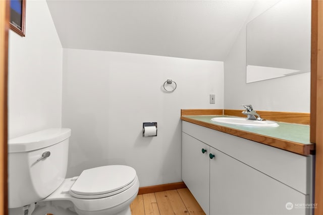 bathroom with hardwood / wood-style floors, vanity, and toilet