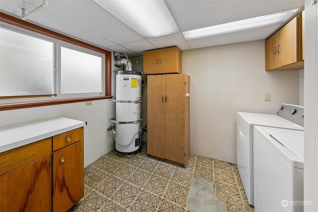 laundry room featuring tile flooring, washing machine and clothes dryer, strapped water heater, and cabinets