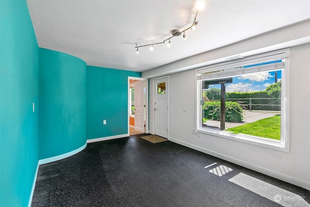 unfurnished room featuring track lighting and plenty of natural light