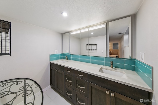 bathroom featuring tile flooring, a textured ceiling, and double vanity