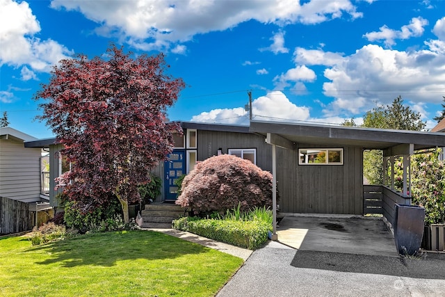 view of front of home with a front yard and a carport