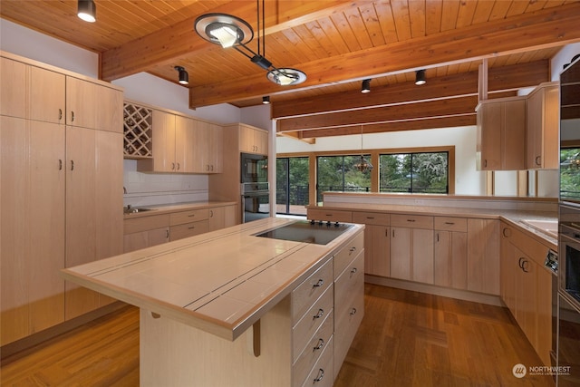 kitchen featuring beam ceiling, light wood-type flooring, black appliances, a breakfast bar, and wooden ceiling