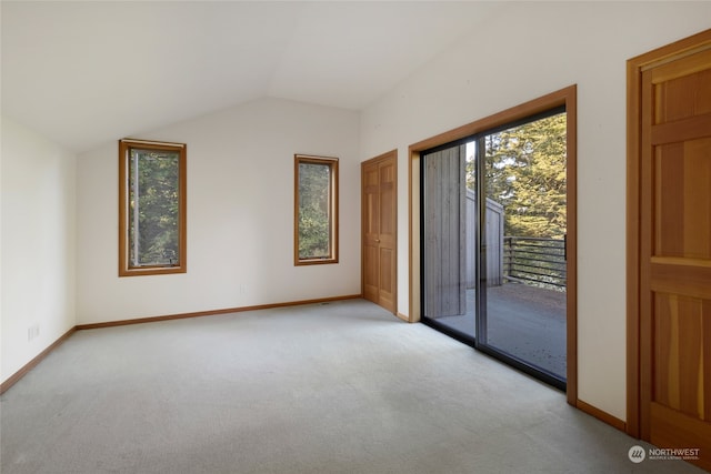 unfurnished room with vaulted ceiling and carpet flooring