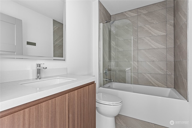 full bathroom featuring vanity, tiled shower / bath combo, and toilet