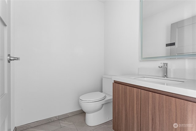 bathroom with tile patterned flooring, vanity, and toilet