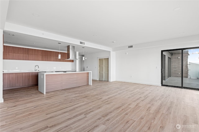 unfurnished living room with light hardwood / wood-style floors and sink