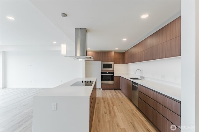 kitchen featuring island exhaust hood, appliances with stainless steel finishes, a sink, modern cabinets, and light wood-type flooring