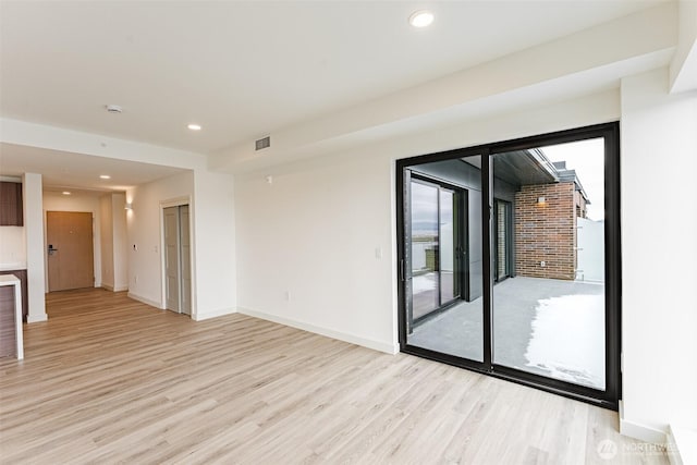 spare room featuring light wood-style floors, baseboards, visible vents, and recessed lighting