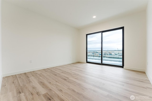 spare room featuring light wood-style flooring, baseboards, and recessed lighting