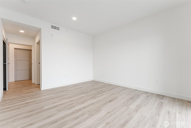 unfurnished room featuring recessed lighting, light wood-type flooring, visible vents, and baseboards