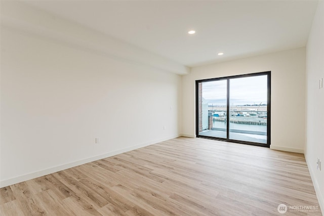 empty room featuring light wood-style floors, recessed lighting, and baseboards