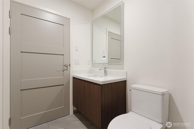 bathroom with vanity, toilet, and tile patterned floors