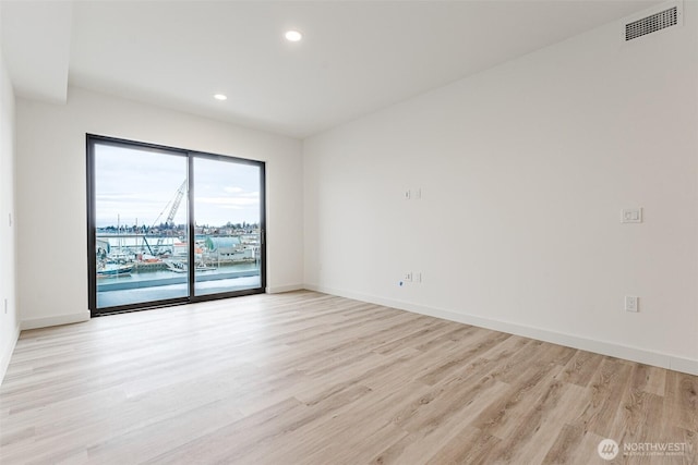 empty room with recessed lighting, visible vents, light wood-style flooring, and baseboards