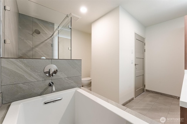 full bathroom with baseboards, tiled shower, and toilet