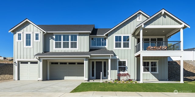 view of front facade with a garage, a balcony, and a front lawn