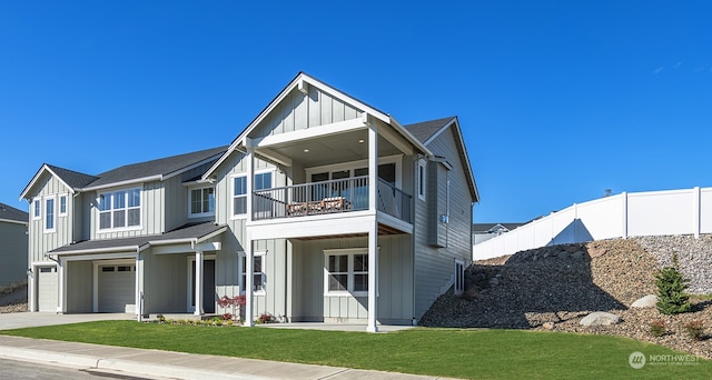 view of front of house with a front yard, a garage, and a balcony