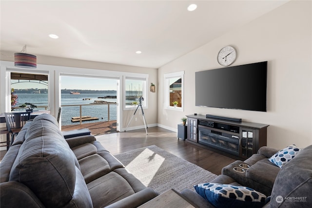 living room with lofted ceiling, a water view, and dark wood-type flooring