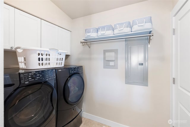 laundry area featuring washer and dryer, cabinets, and light tile flooring