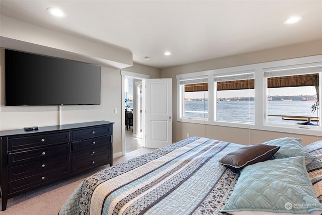 carpeted bedroom featuring a water view