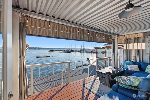 dock area with an outdoor hangout area, a balcony, and a water view