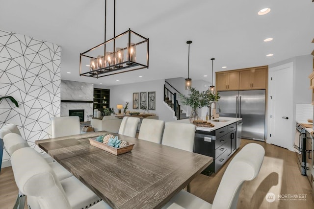 dining room featuring a fireplace, sink, and light wood-type flooring