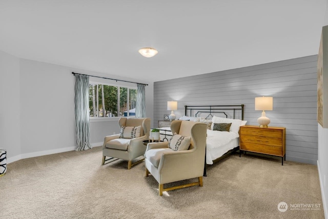 bedroom featuring light carpet and wooden walls