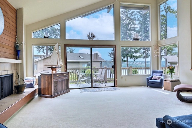 living room with carpet, a towering ceiling, and a fireplace