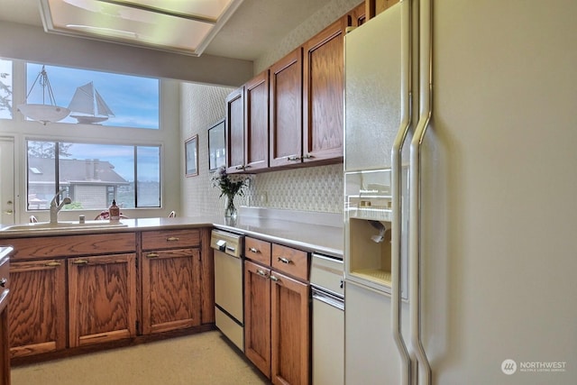 kitchen featuring sink, tasteful backsplash, dishwasher, and white refrigerator with ice dispenser