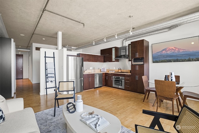 living area with light wood-type flooring and track lighting