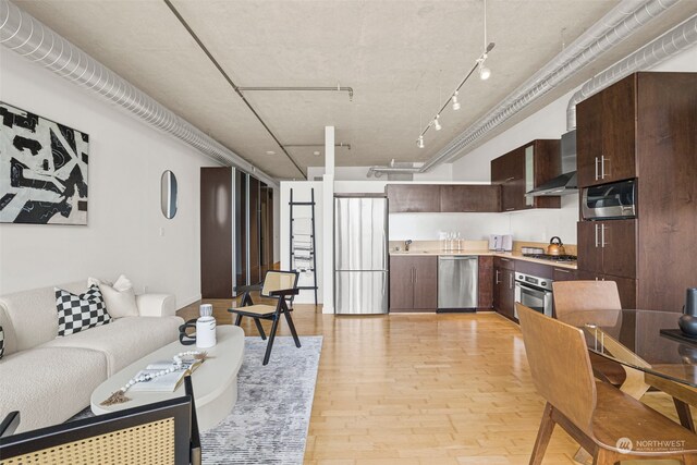 living room with sink, rail lighting, and light hardwood / wood-style floors