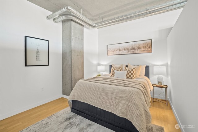 bedroom featuring wood finished floors and baseboards