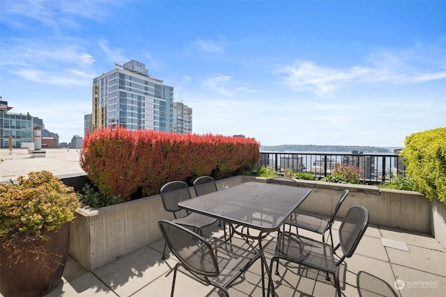 view of patio with a view of city and outdoor dining area