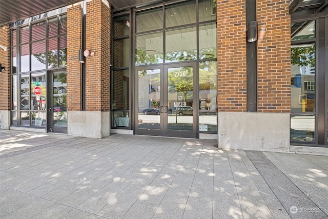 view of exterior entry with brick siding and french doors