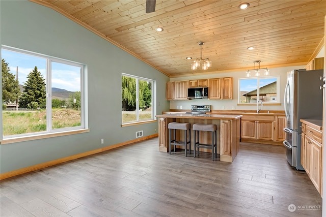 kitchen featuring stainless steel appliances, hardwood / wood-style floors, a kitchen island, and wood ceiling