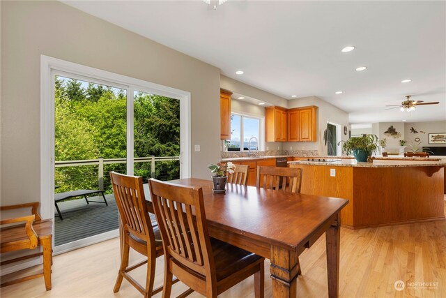 dining space with ceiling fan, sink, and light wood-type flooring