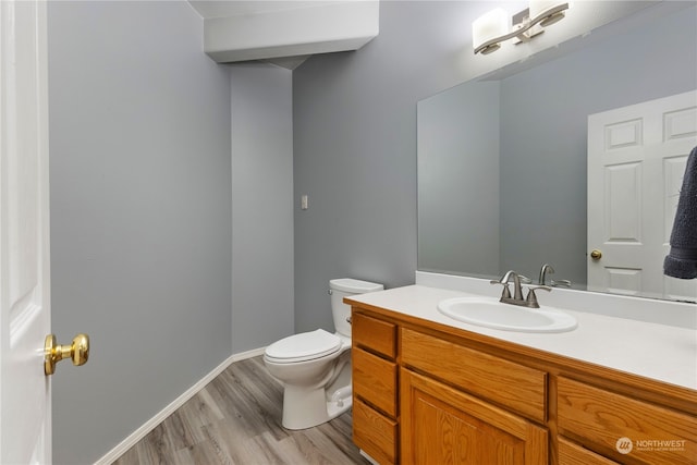 bathroom featuring vanity, wood-type flooring, and toilet