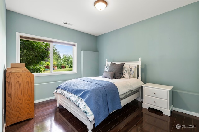 bedroom with dark hardwood / wood-style floors