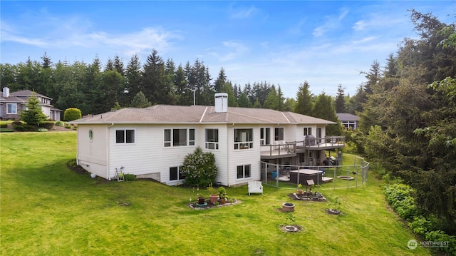 rear view of house featuring a wooden deck and a yard