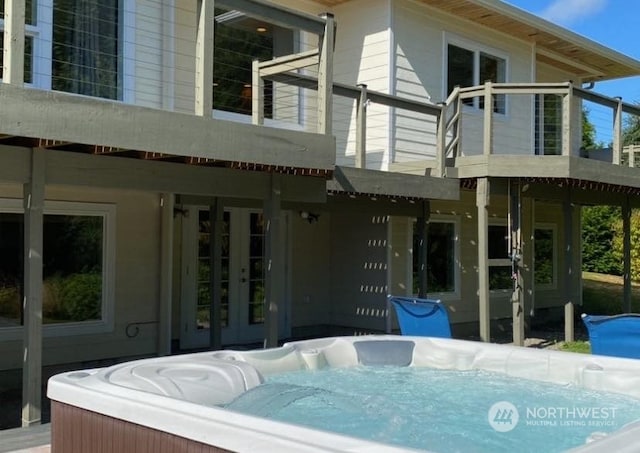 back of house with a balcony and a hot tub