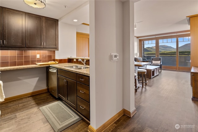 kitchen with backsplash, hardwood / wood-style floors, sink, and stainless steel dishwasher