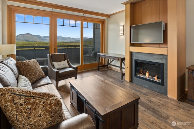 living room featuring crown molding, a wealth of natural light, a mountain view, and dark hardwood / wood-style flooring