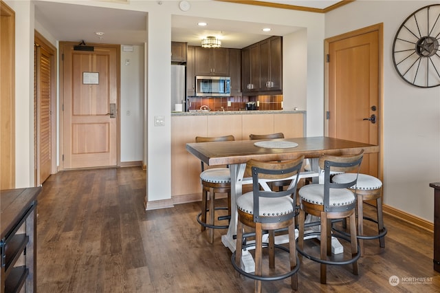 dining room with crown molding and dark hardwood / wood-style flooring