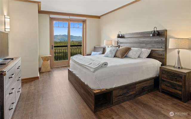 bedroom with dark hardwood / wood-style flooring, a mountain view, access to exterior, and crown molding