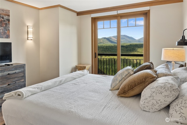 bedroom with access to outside, a mountain view, crown molding, and multiple windows