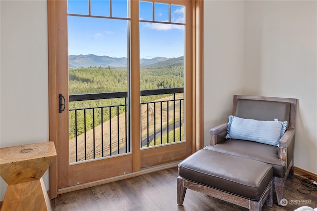 sitting room featuring a mountain view and dark wood-type flooring