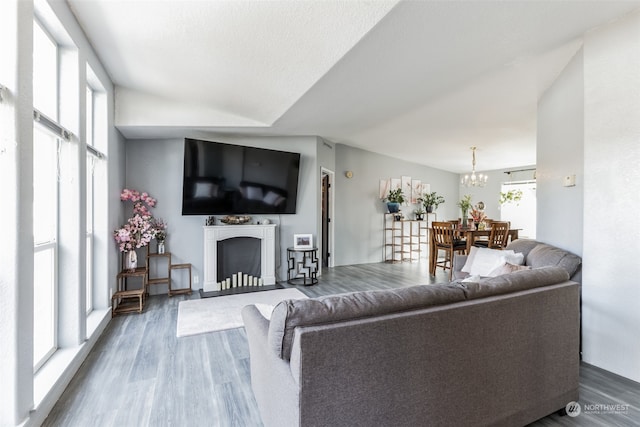 living room with a chandelier, a wealth of natural light, and dark hardwood / wood-style flooring