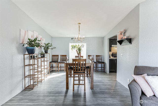 dining area with dark hardwood / wood-style flooring and a chandelier