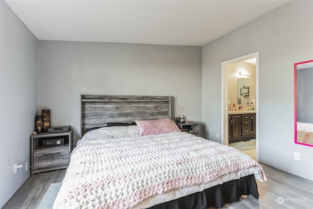 bedroom with light hardwood / wood-style flooring and connected bathroom