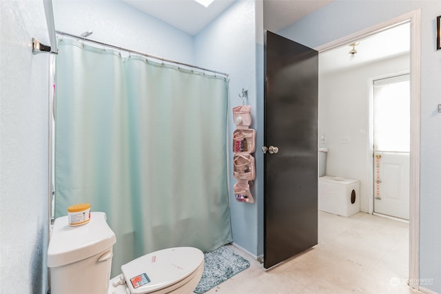 bathroom featuring tile flooring and toilet